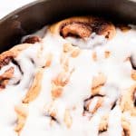 Cinnamon rolls with protein in a skillet with a protein packed greek yogurt glaze.