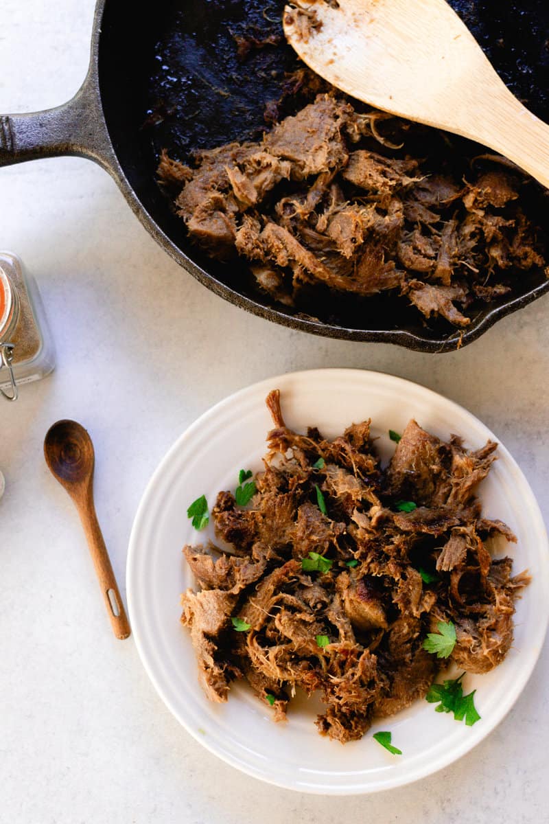 Slow cooked, shredded beef tongue garnished with fresh parsley.