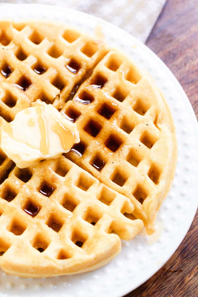 Waffles with no milk in the recipe ready to be enjoyed with butter and syrup.