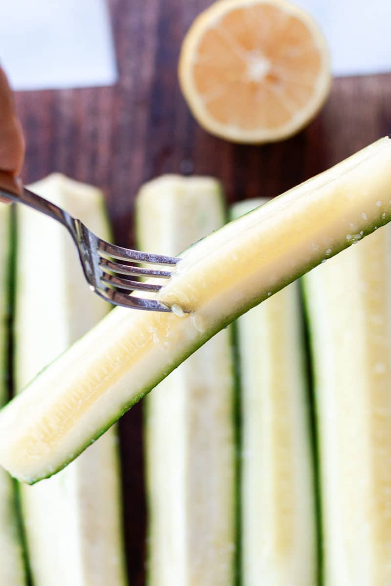 A boiled zucchini wedge on the end of a fork.