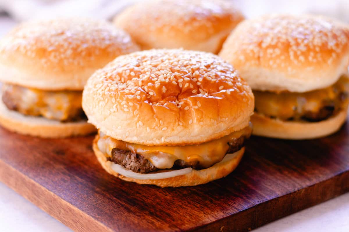 Thick, juicy moose burgers with sesame seed buns brushed with butter.