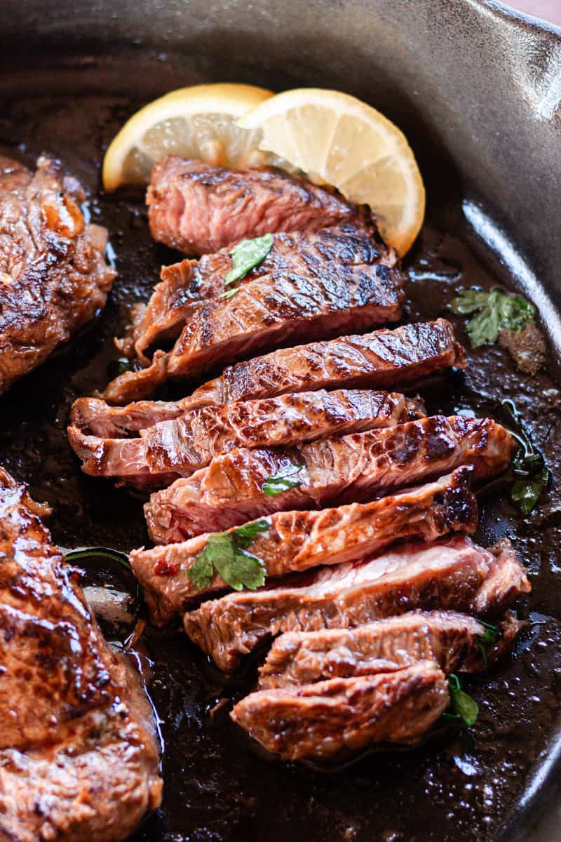 Thinly sliced moose steak and moose chops in a large cast iron skillet.