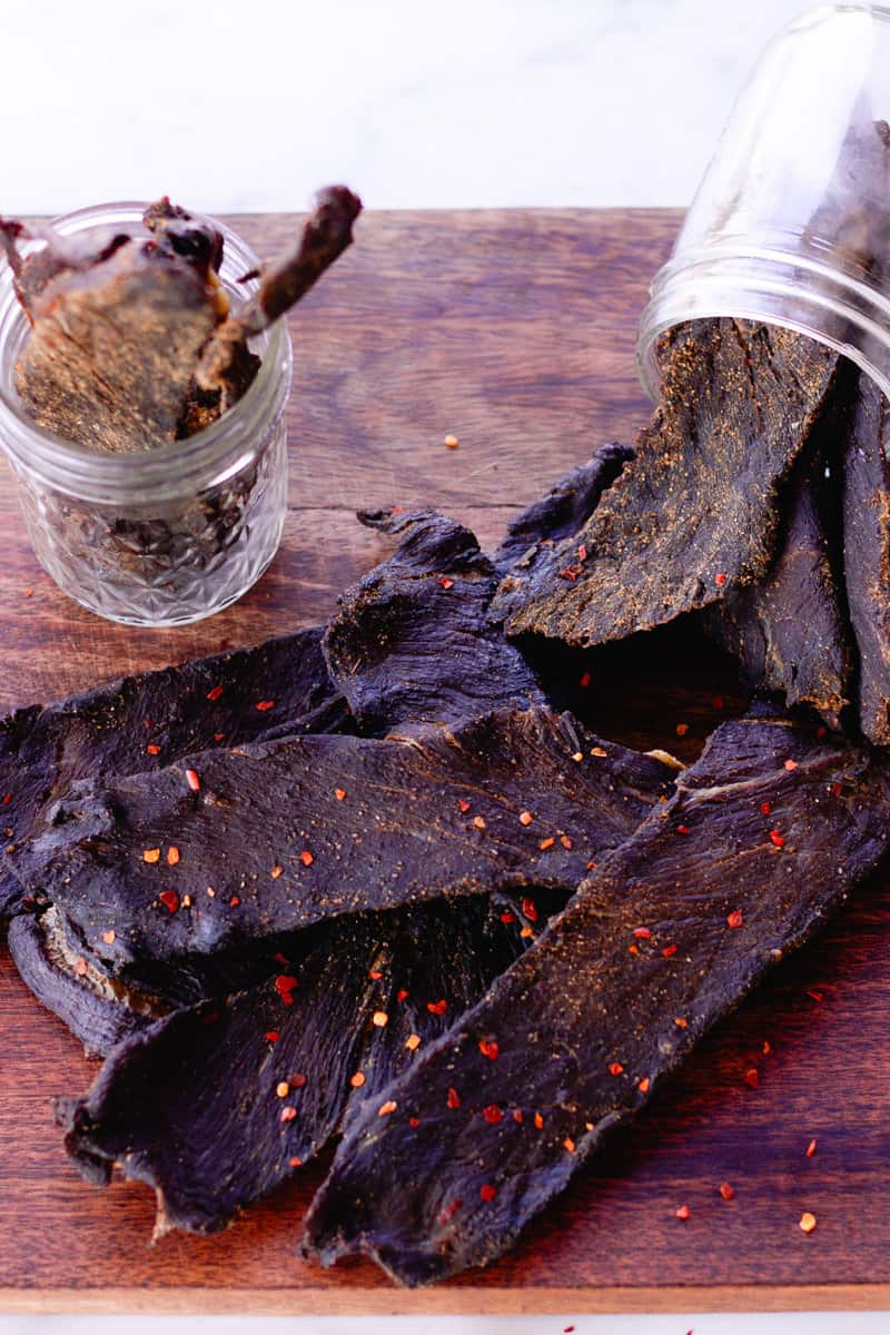 Dried elk jerky poured out of a glass container.