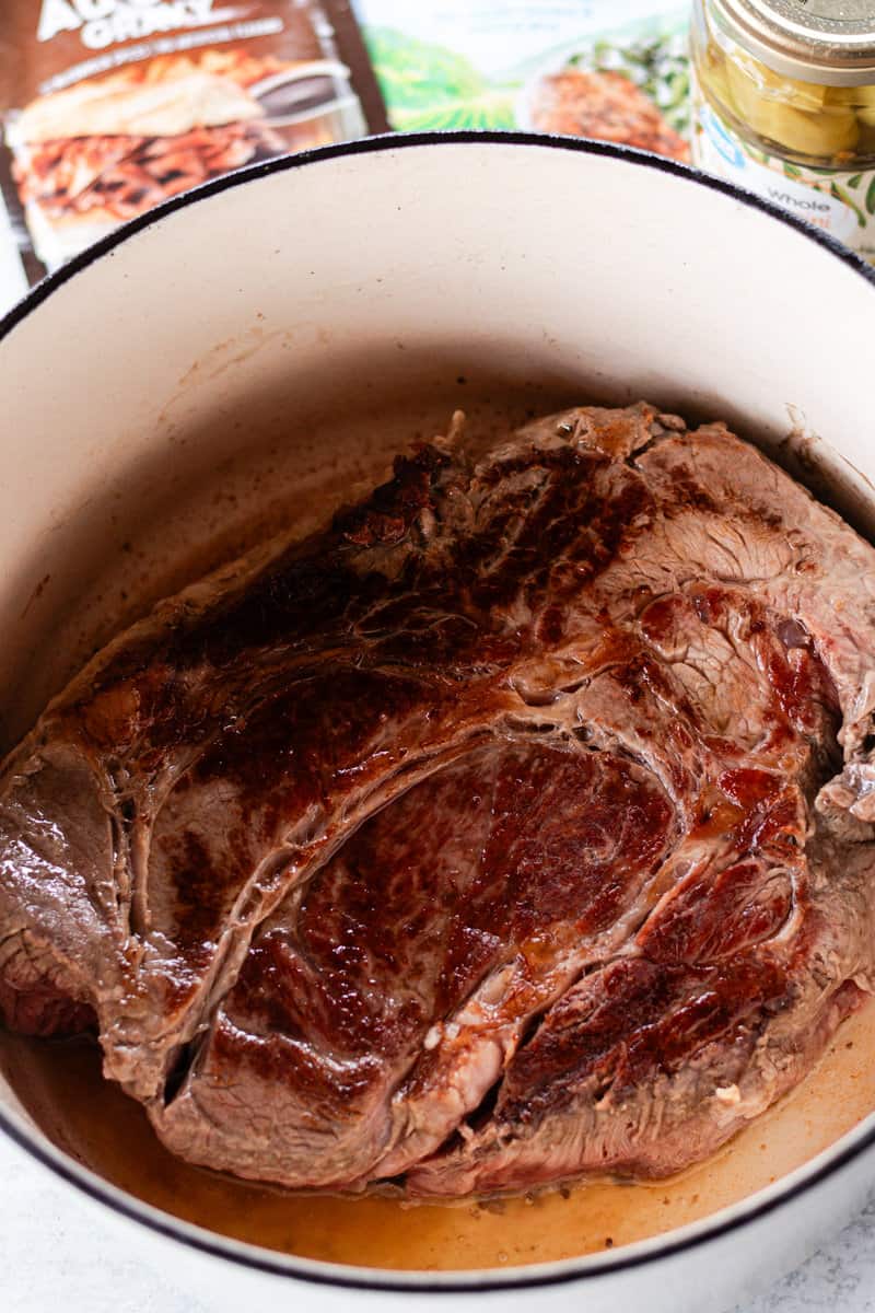 Searing a pot roast in a dutch oven.