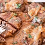 Sticking a fork into a sliced moose chop that is smoothered in a gravy.