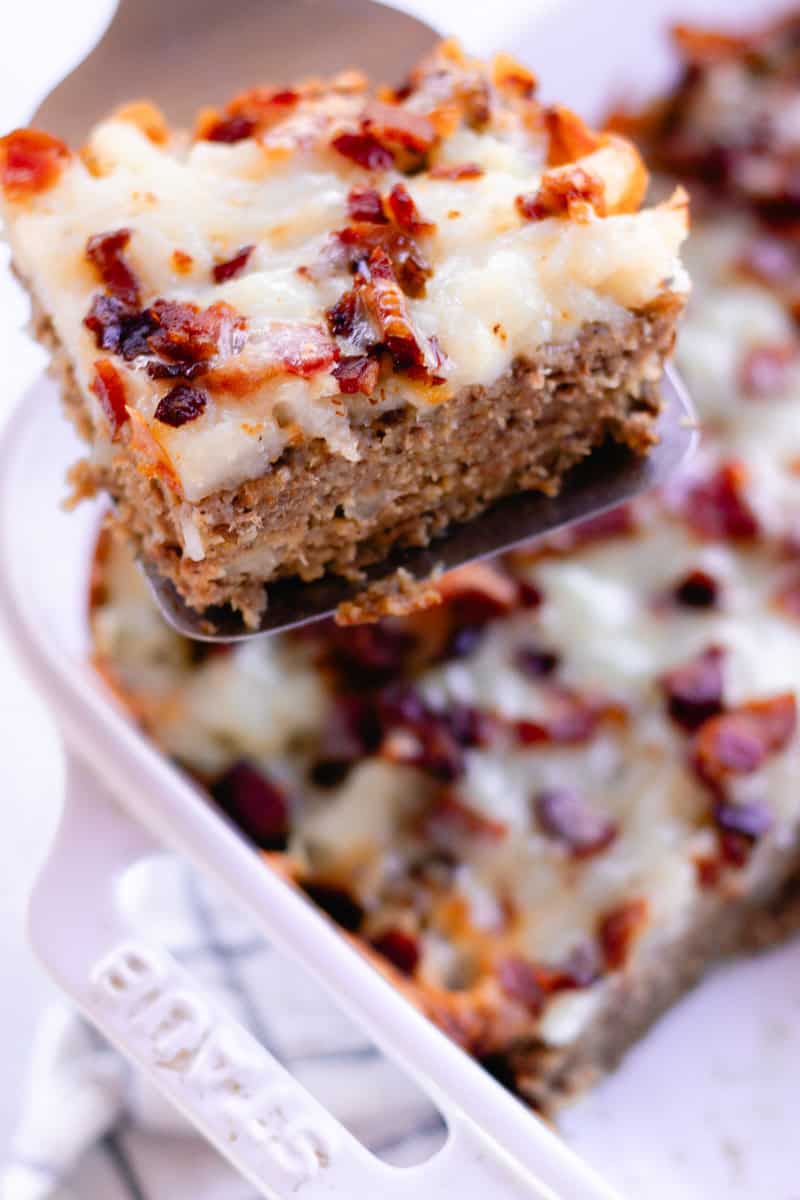 Moose meatloaf casserole with loaded baked potato on top and melted cheese and bacon.