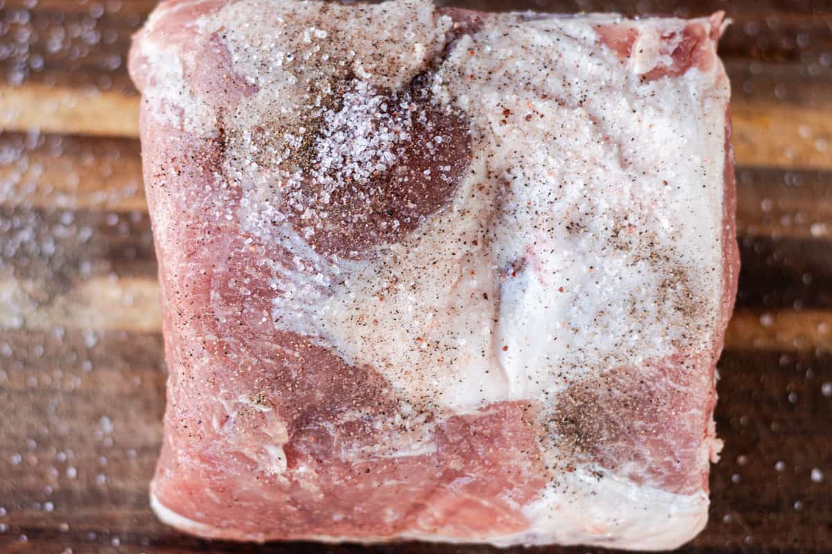 Seasoning the pork with salt and pepper.