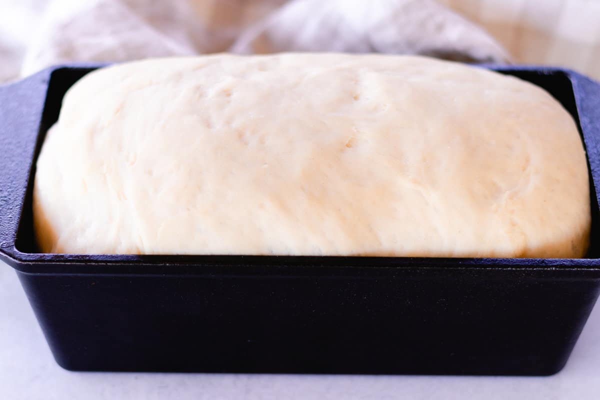 Dough in a cast iron loaf pan.