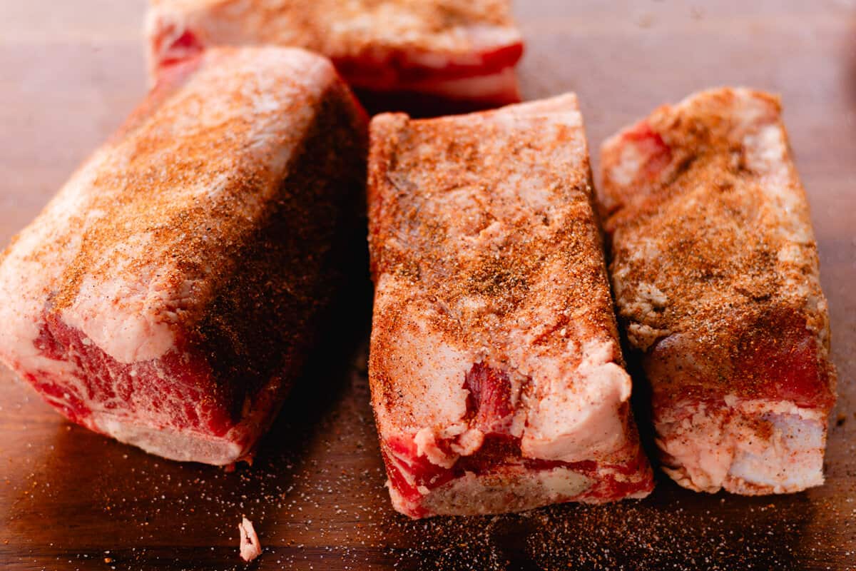 Coating the ribs with a dry seasoning rub.