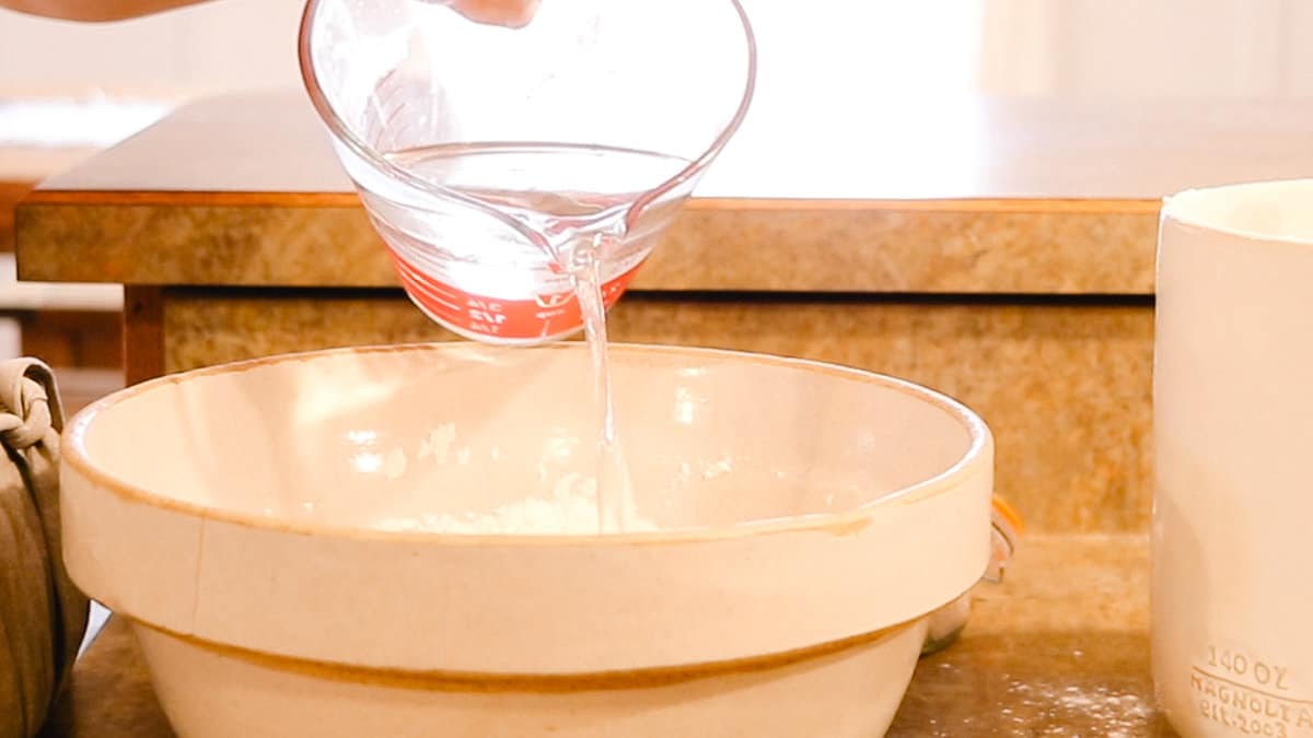 Pouring water into a glass mixing bowl.