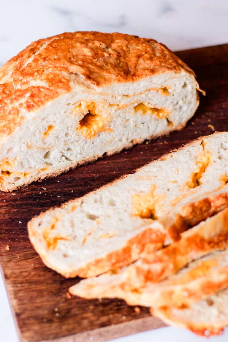 Dutch oven cheesy bread on a wooden board.