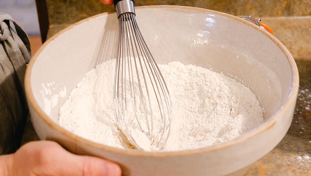 Whisking the dry ingredients together in a bowl for bread.