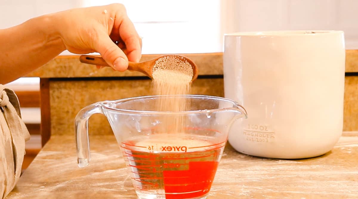 Adding yeast to a measure glass that contains warm water. 