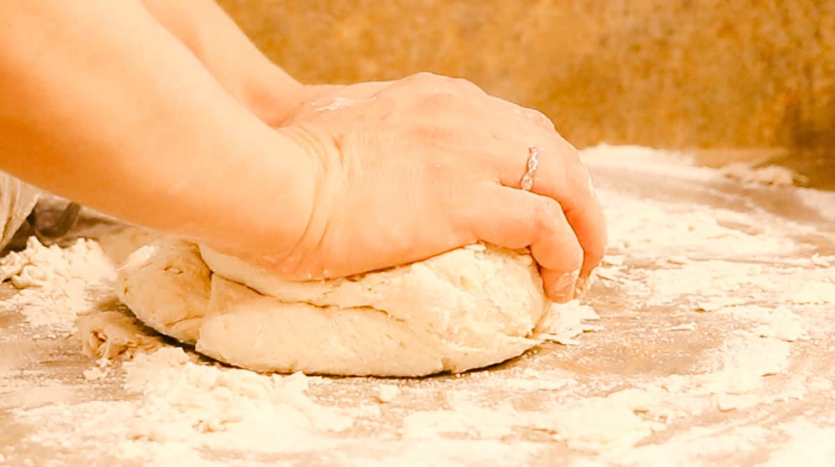 Kneading the bagel dough on a counter. 