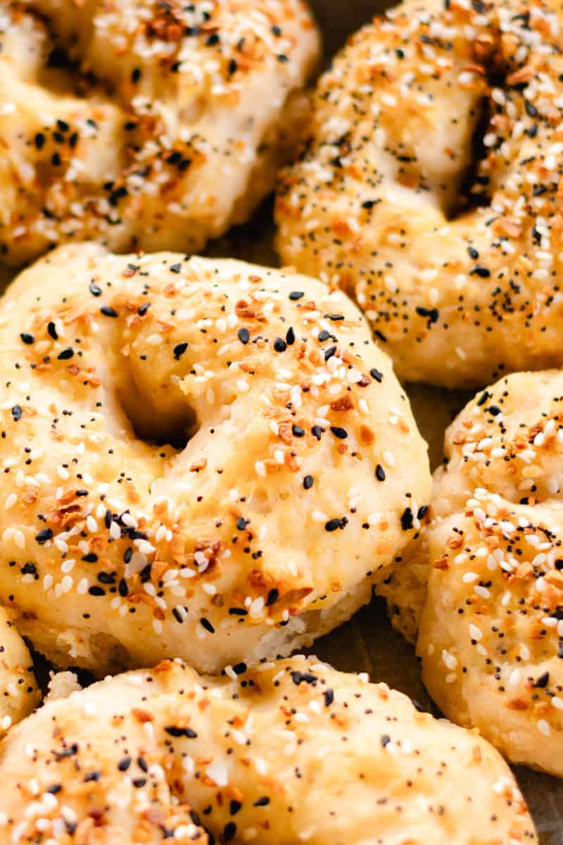 A homemade Greek yogurt bagel with "Everything Bagel Seasoning" topping, surrounded by more bagels.