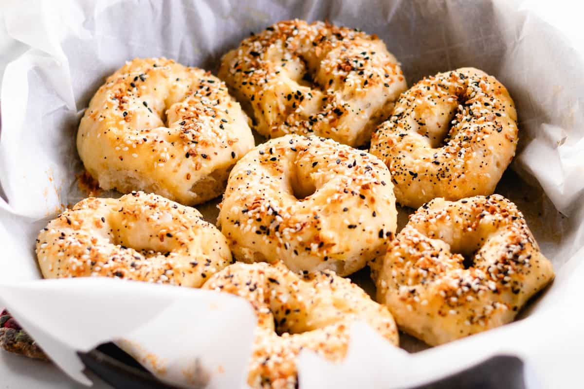 Freshly baked homemade Greek yogurt bagels in a parchment-lined cast iron skillet.