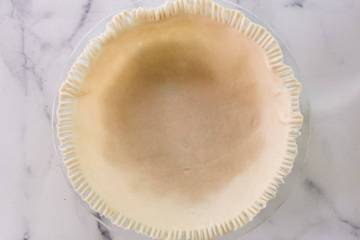 Plain pie crust for the pot pie pressed into the bottom of the pie dish.