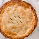 A baked chicken pot pie on a marble countertop.
