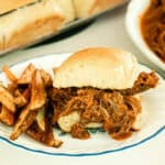 Homemade pulled beef sandwich on a fresh homemade bun with crispy french fries.