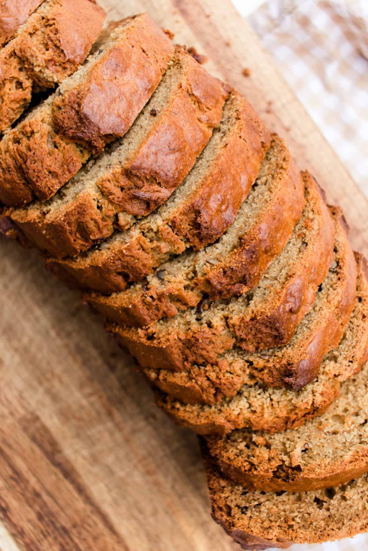 Sliced skillet banana bread on wooden cutting board.