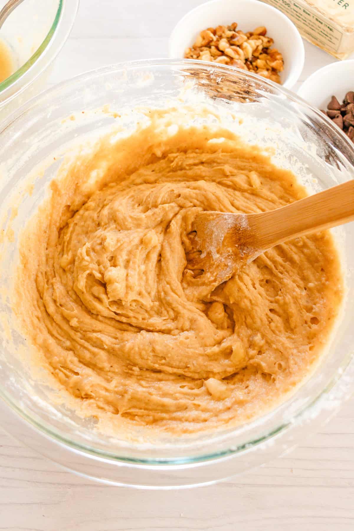 Combing the wet and dry ingredient in the larger mixing bowl with a wooden spatula. 