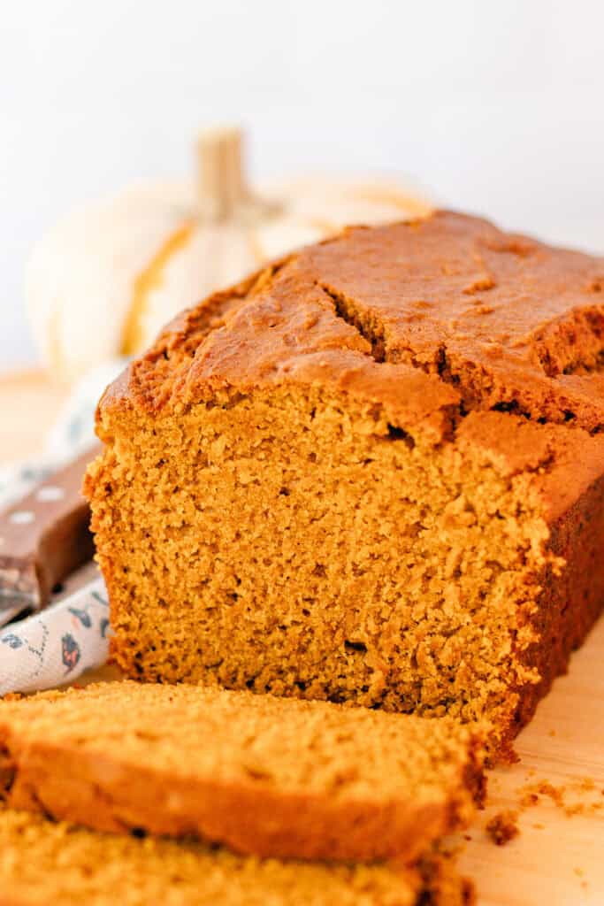 Homemade pumpkin bread with several slices removed so you can see the inside.