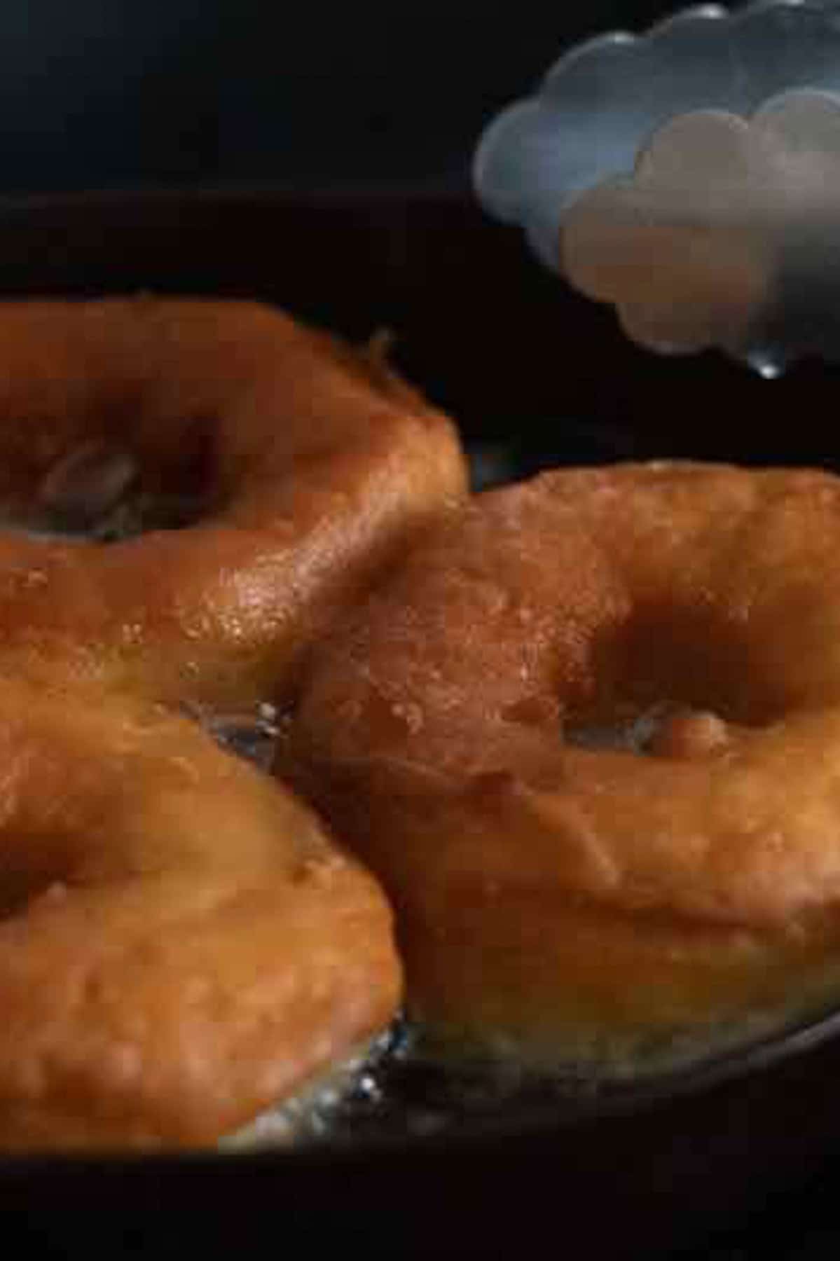 Frying the donuts in hot oil in a cast iron skillet. 