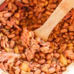 Dutch oven baked beans in a large pot with chunks of ham hock.