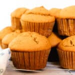 Fluffy muffins freshly made from pumpkin puree on a white counter.