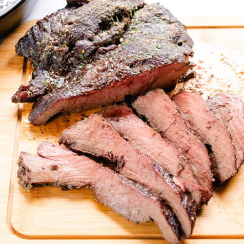 Oven roasted beef heart resting on a cutting block.