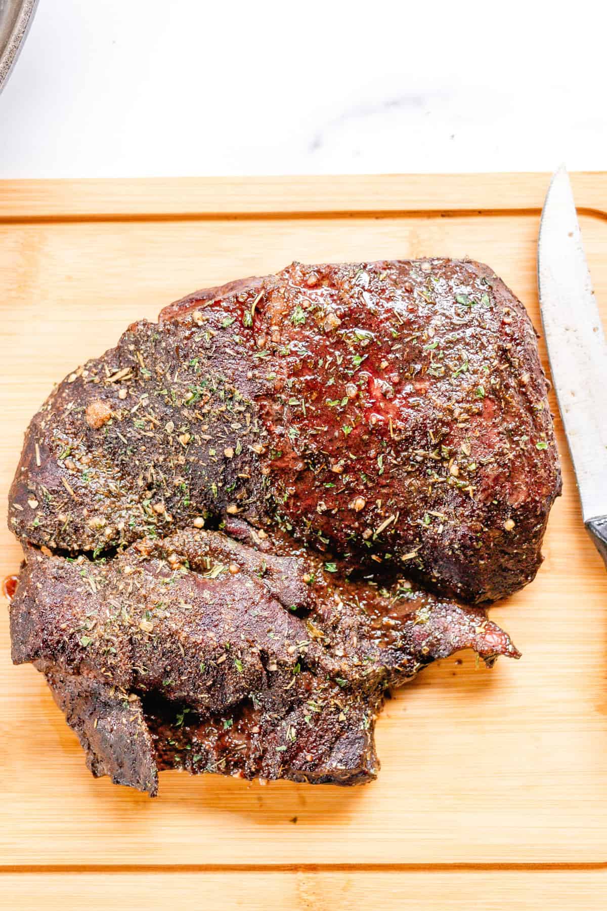 Letting the roasted heart rest on a wooden cutting board before cutting into it.