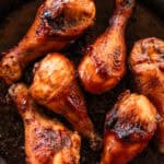 Cast iron drumsticks with caramelized barbecue sauce painted on the sides.