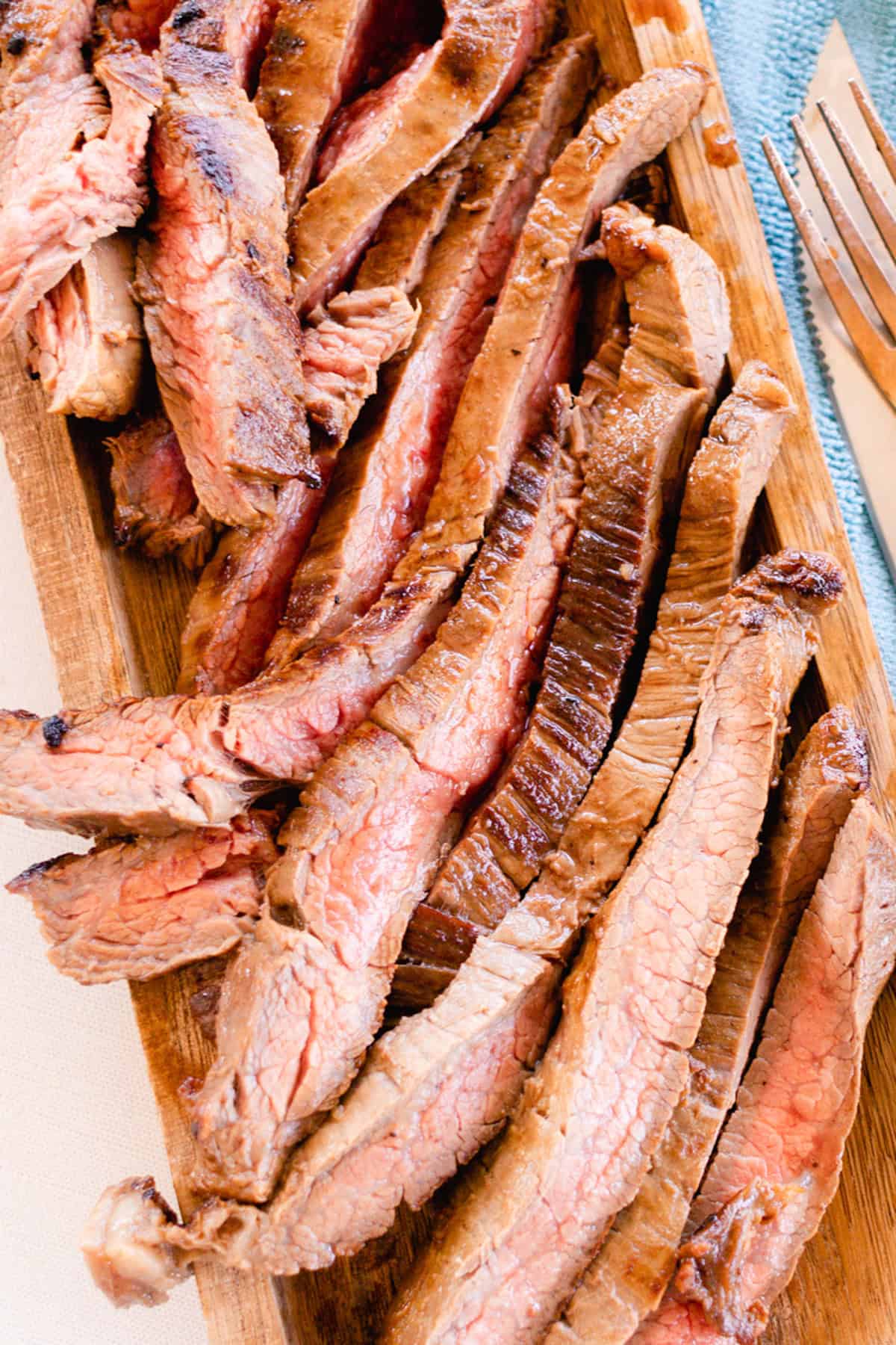 Cutting a flank steak into thin slices across the grain.