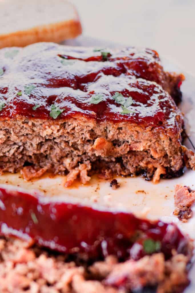 Elk meatloaf cut into thick slices so that you can see the bits of bacon inside.