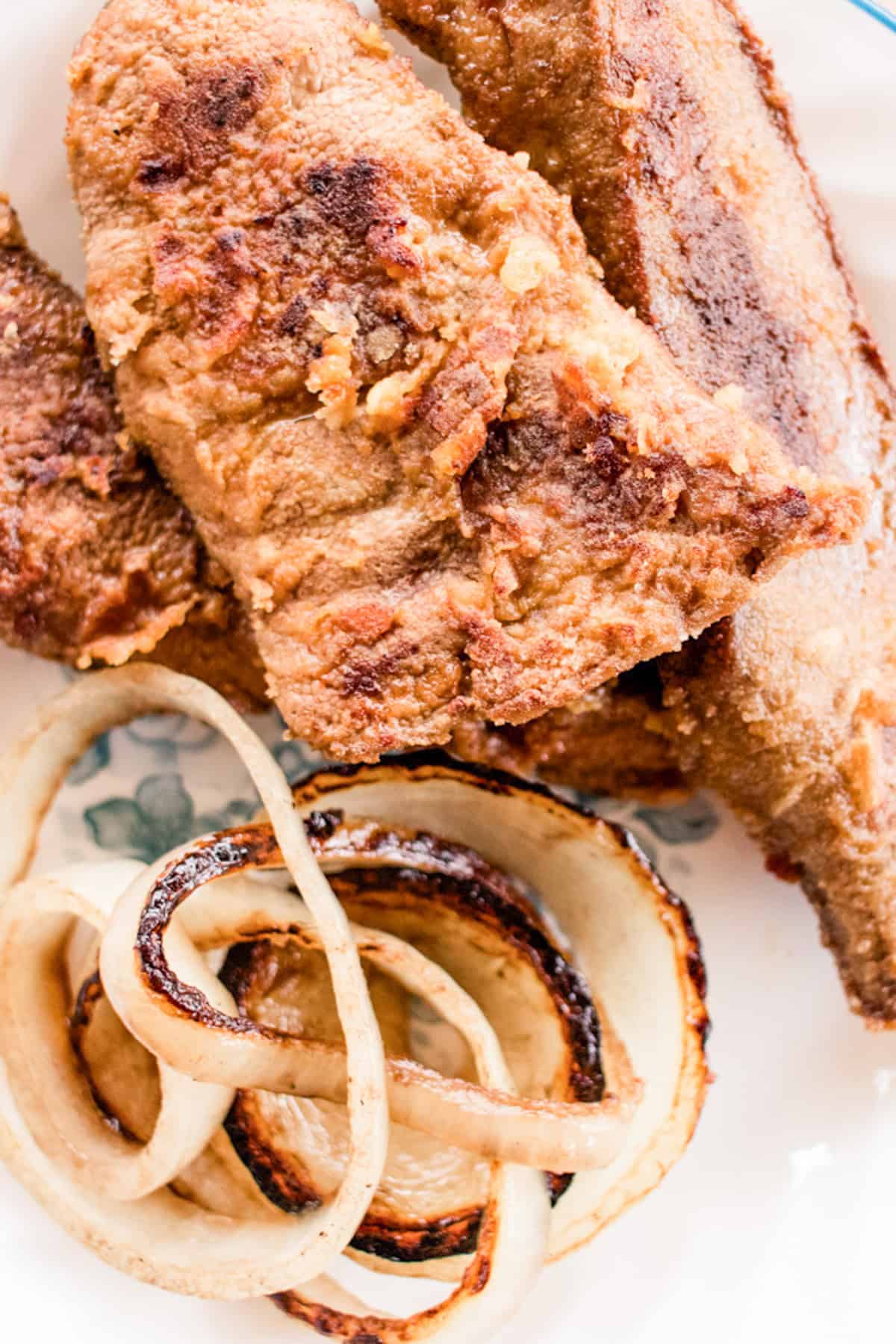 Fried and breaded liver strips with onion rings.