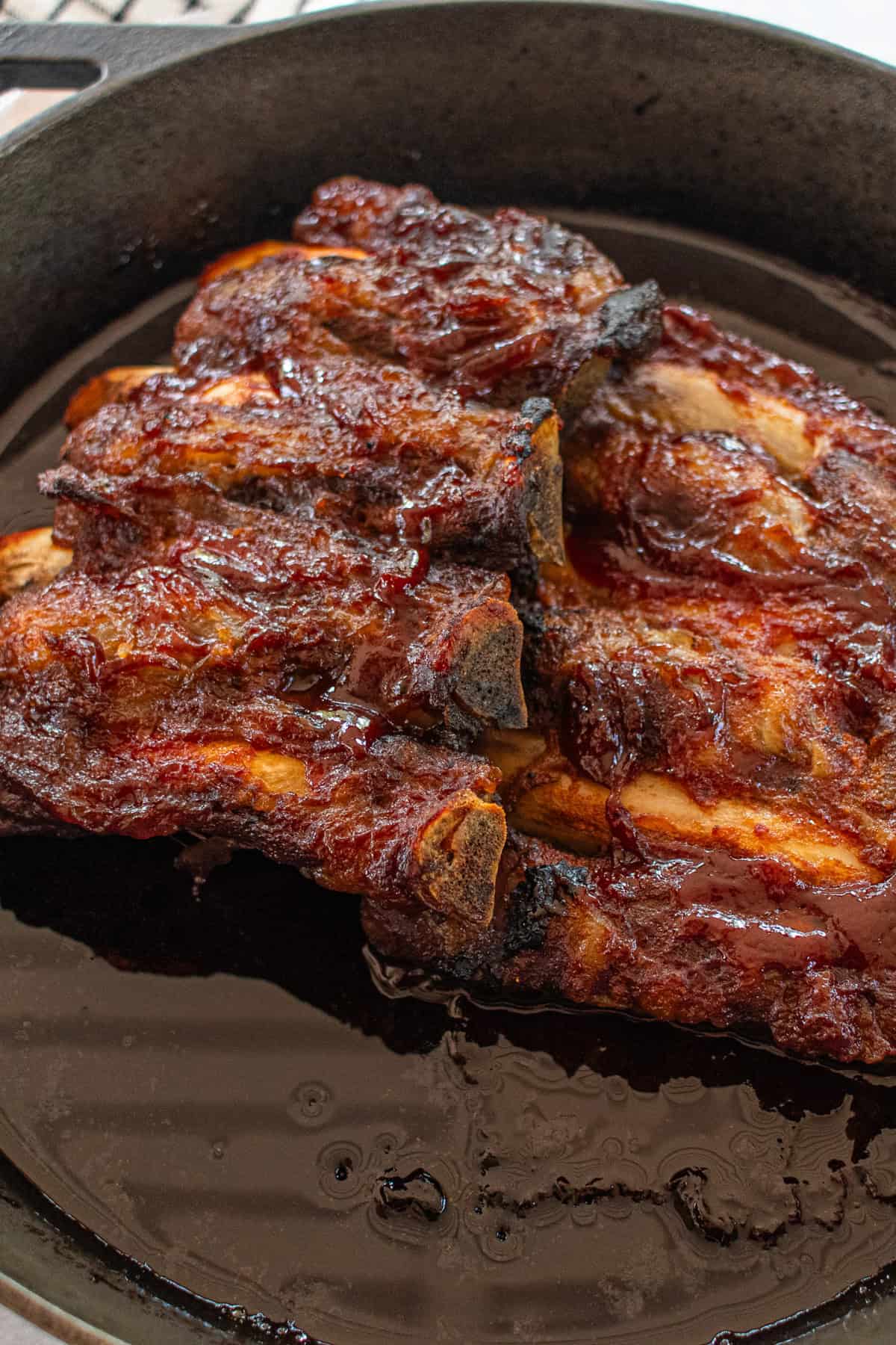 Baked beef back ribs cooling in a cast iron skillet. 