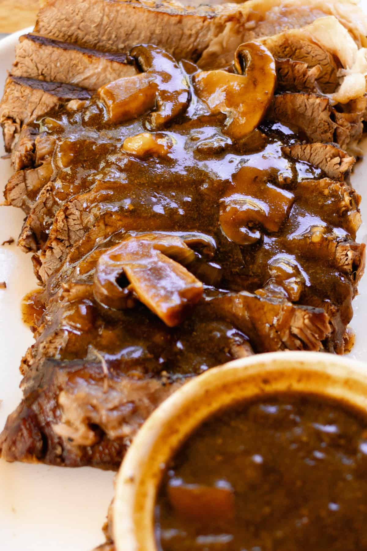 Pouring the dark gravy with mushrooms ontop of the heel of round pikes peak roast.