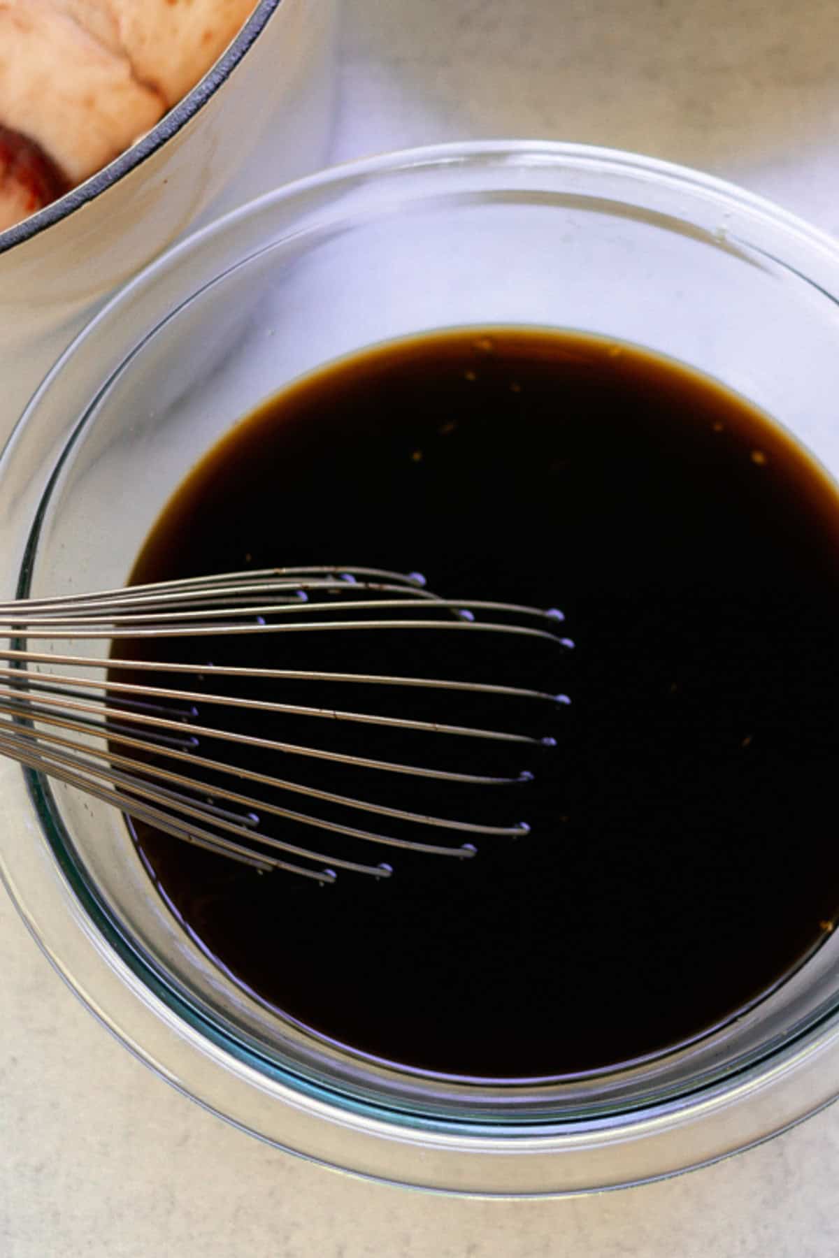 Mixing coffee and soy sauce in a small mixing bowl with a wire whisk. 