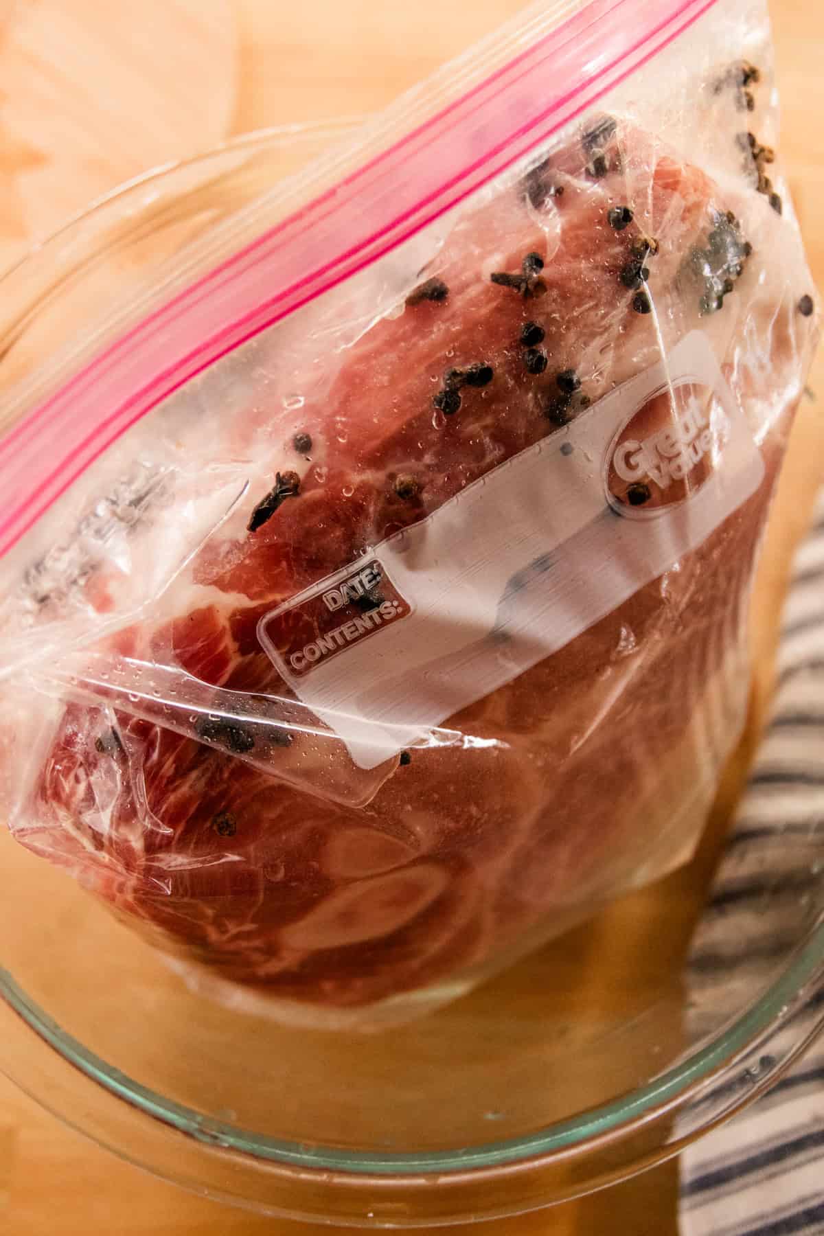 Placing the roast in with the brine in a large zippered bag. 