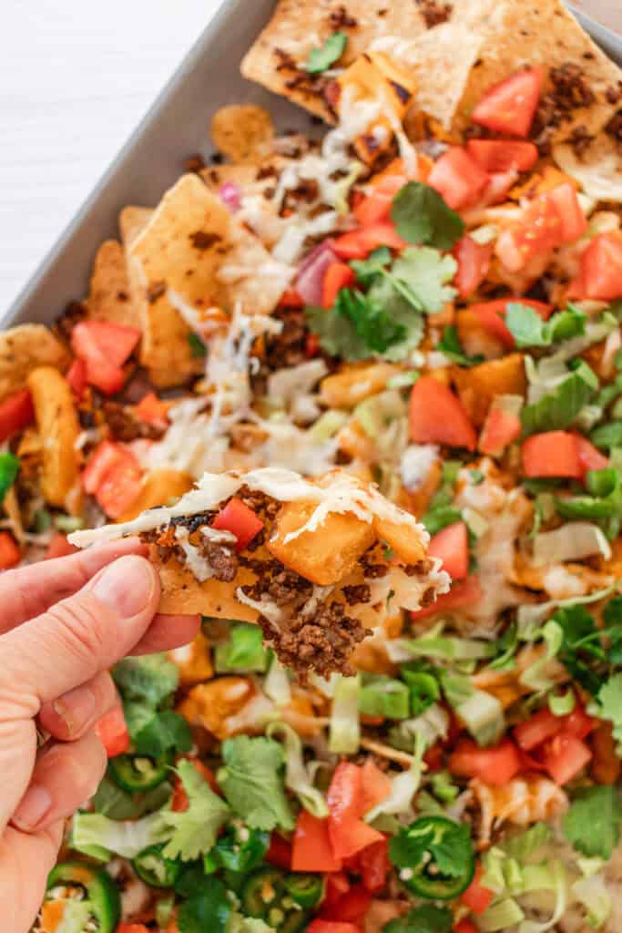 Scooping up a heap of pumpkin nachos onto a chip.