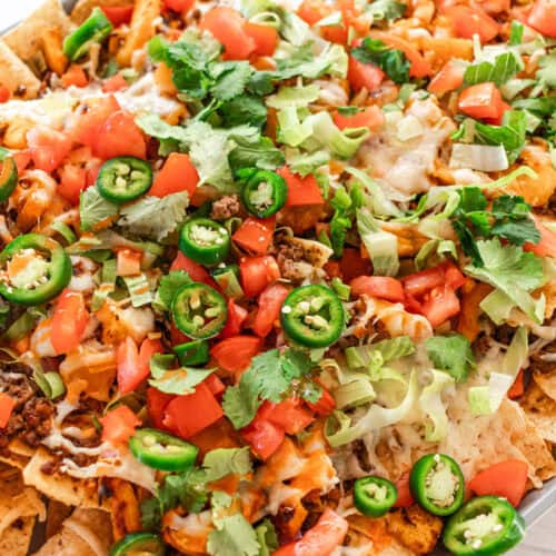 Pumpkin nachos with cheese and topped with fresh vegetables.