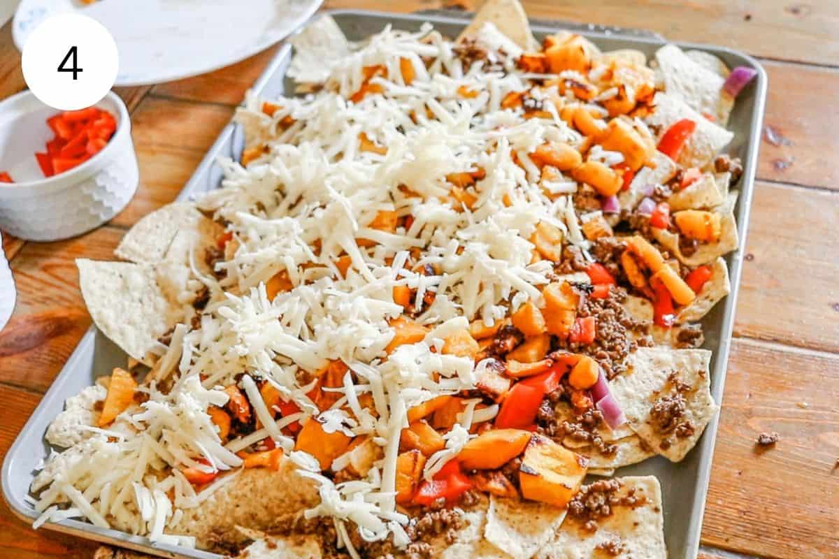 Layering the top of the pumpkin nachos with cheddar cheese.