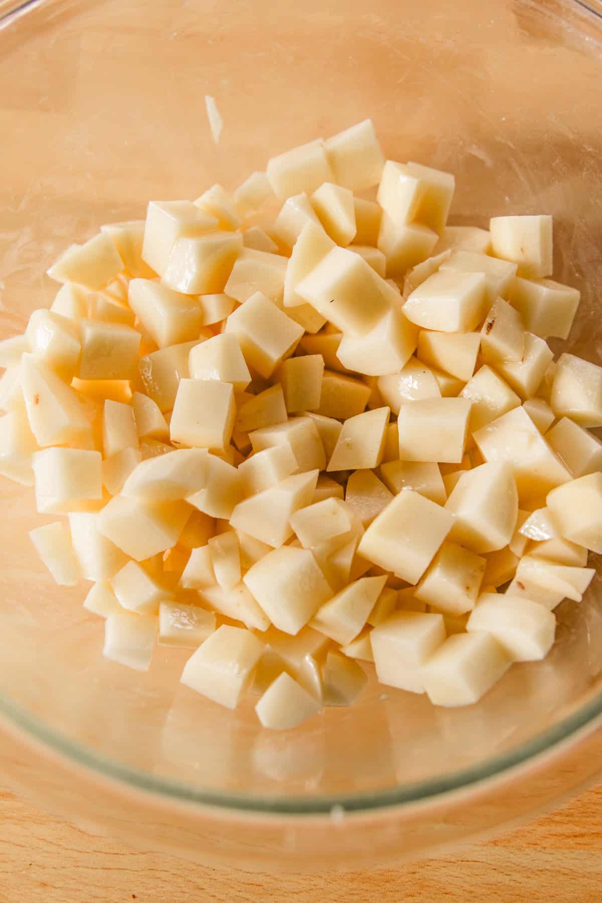 Tossing the diced potatoes in butter.