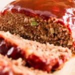Venison meatloaf on a wooden cutting board with a homemade barbecue glaze on top.