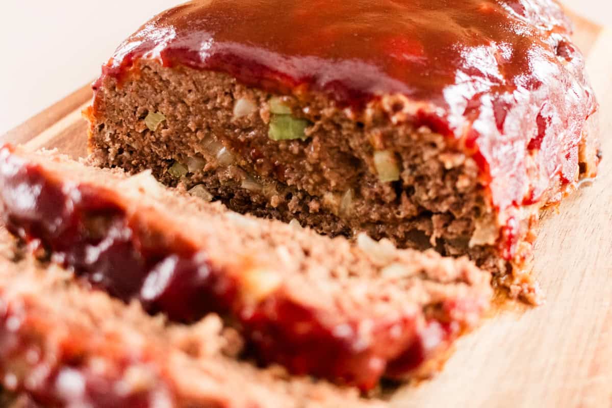 Venison meatloaf on a wooden cutting board with a homemade barbecue glaze on top.