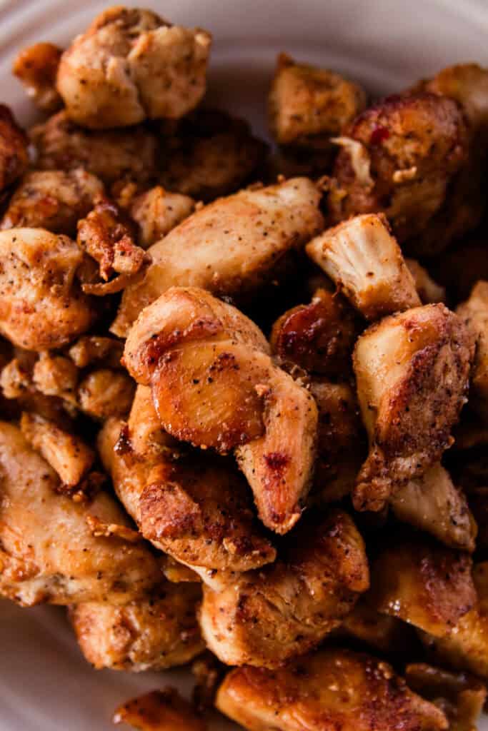 Pile of cajun chicken bites that are crispy and heavily layered with seasonings.