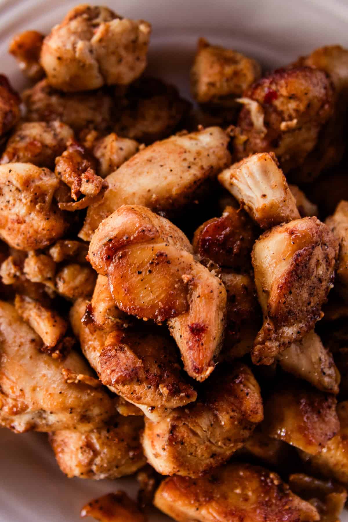 Pile of cajun chicken bites that are crispy and heavily layered with seasonings.