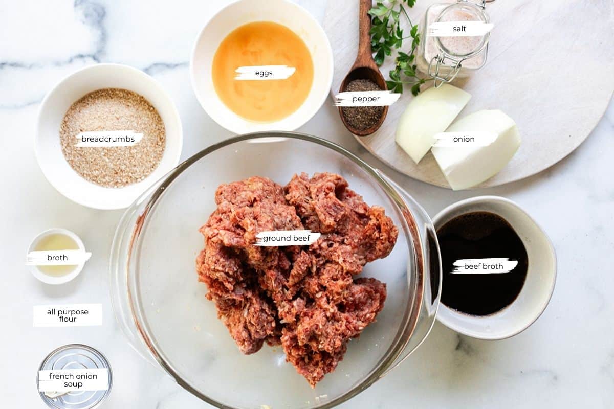 Ingredients to make salisbury steak separated into individual bowls on a marble countertop. 