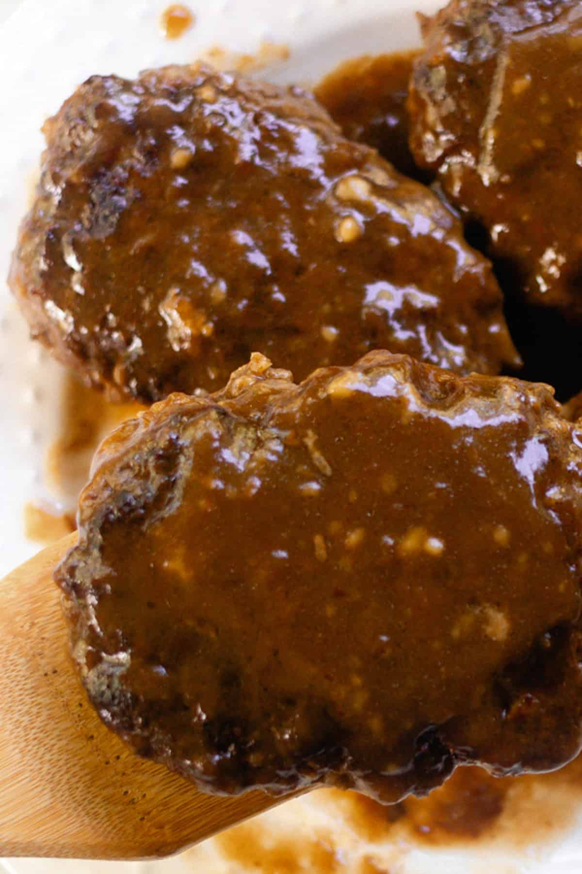 French onion soup and salisbury steak on a glass plate.