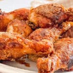 Fresh Cast Iron Buttermilk Fried Chicken drumsticks on a plate.